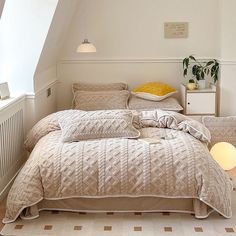 a bed sitting in a bedroom next to a window with a lamp on top of it