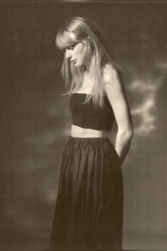 a black and white photo of a woman with long hair wearing a cropped top