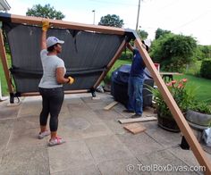 two people are working on an outdoor swing set that is being built in the backyard