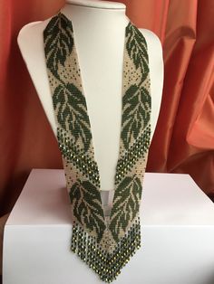 a white mannequin with green beaded necklaces on it