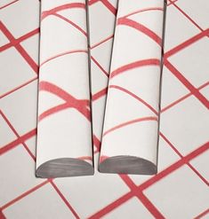 two red and white striped papers on top of each other with one rolled up in the middle