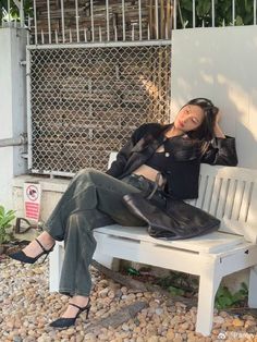 a woman is sitting on a white bench