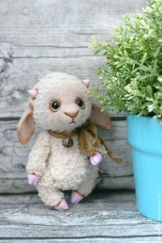 a stuffed animal sitting next to a potted plant