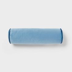 a rolled up blue pillow sitting on top of a white wall