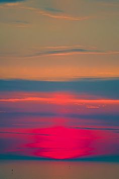 the sun is setting over the ocean with sailboats in the water and clouds in the sky