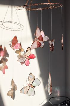 a mobile with butterflies hanging from it's sides in front of a light fixture