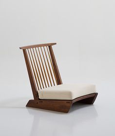 a wooden chair with a white cushion on it's back and seat pad in the middle