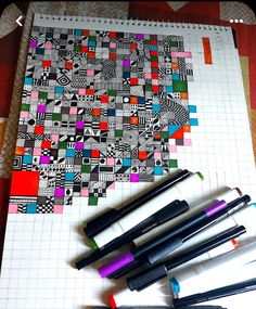 several pens are lined up next to each other on a piece of paper with an abstract design