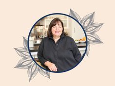 a woman standing in front of a kitchen counter with flowers on it's side