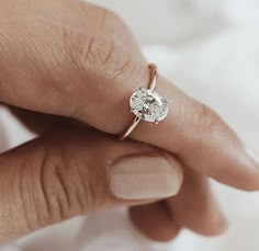 a woman's hand with a diamond ring on it