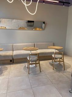 a couple of tables sitting next to each other on top of a tiled floor in a room