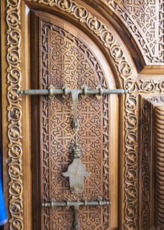 an ornate wooden door with metal handles