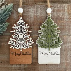 two wooden christmas tree ornaments hanging from twine