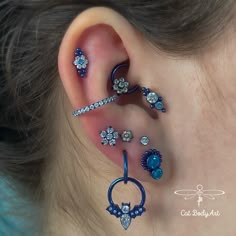 an ear with three different types of piercings on it