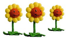 three crocheted flowers with faces on them