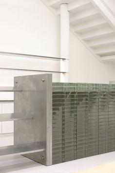 a metal object sitting on top of a white floor next to a stair case in a building