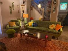 a living room filled with green couches and colorful pillows