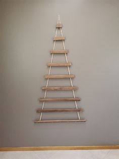 a christmas tree made out of wooden slats hanging on the side of a wall