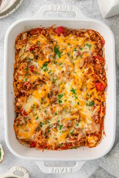 a casserole dish with meat, cheese and vegetables in it on a table