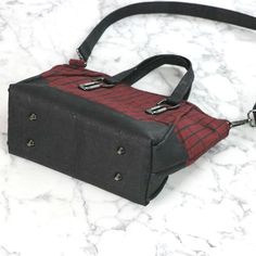 a small black and red bag sitting on top of a marble counter