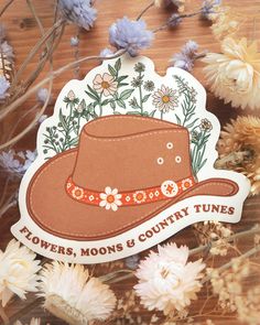 a sticker that says flowers, moons and country tunes with a hat on it