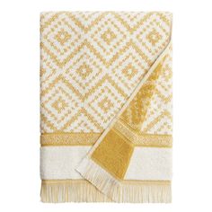 the gold and white towel is folded on top of each other, with fringes