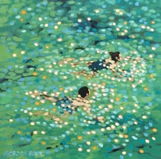 two people swimming in a body of water with bubbles floating on the water and green grass