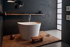 a white bath tub sitting on top of a wooden floor