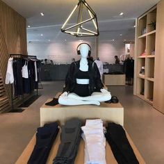 a mannequin sitting on top of a wooden table in front of a display