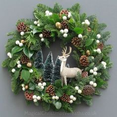 a christmas wreath with a deer and pine cones