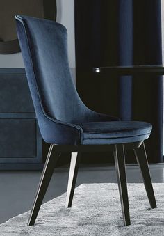 a blue chair sitting on top of a rug in front of a table and window