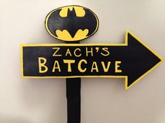 a black and yellow sign that says zach's batcave with a batman symbol on it