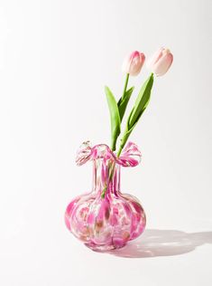 a pink vase with two flowers in it