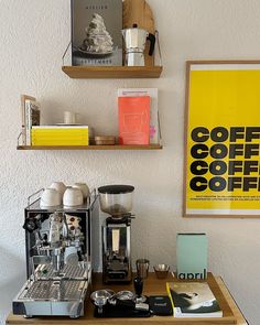 a coffee machine sitting on top of a wooden table next to two shelves filled with books