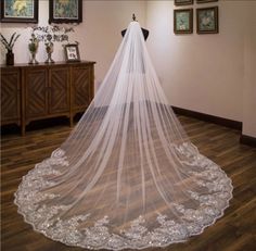 a white wedding veil on top of a wooden table in a room with pictures and paintings