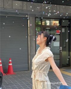 a woman standing in front of a building with bubbles coming out of the windows and doors