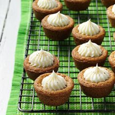 cupcakes with white frosting on a cooling rack