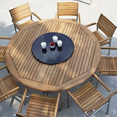 a round wooden table with chairs around it