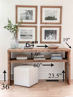 a wooden table with pictures on the wall above it and a vase filled with flowers