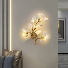 a wall mounted light with white flowers on it in the corner of a living room