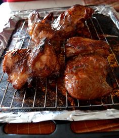 some meat is cooking on a grill with tin foil