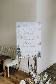 a welcome sign sitting on top of a wooden easel next to a white bench