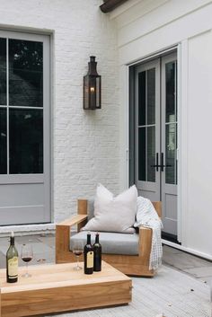 an outdoor living area with two couches and bottles of wine