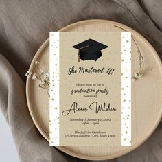 a graduation party card on top of a wooden plate with flowers in front of it