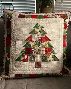 a quilted christmas tree pillow sitting on top of a couch