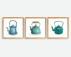 three tea kettles are hanging on the wall in front of two framed pictures, one is