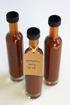 three bottles of pumpkin spice sit next to each other on a white surface with a price tag