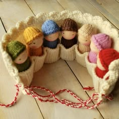 small knitted dolls in a basket on a wooden floor