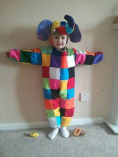 a child in a clown costume standing on the floor