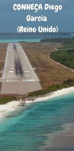 an airplane is parked on the runway in front of some blue water and green trees